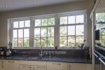 Quickslide sash windows illuminate the kitchen with natural light, enhancing its charm