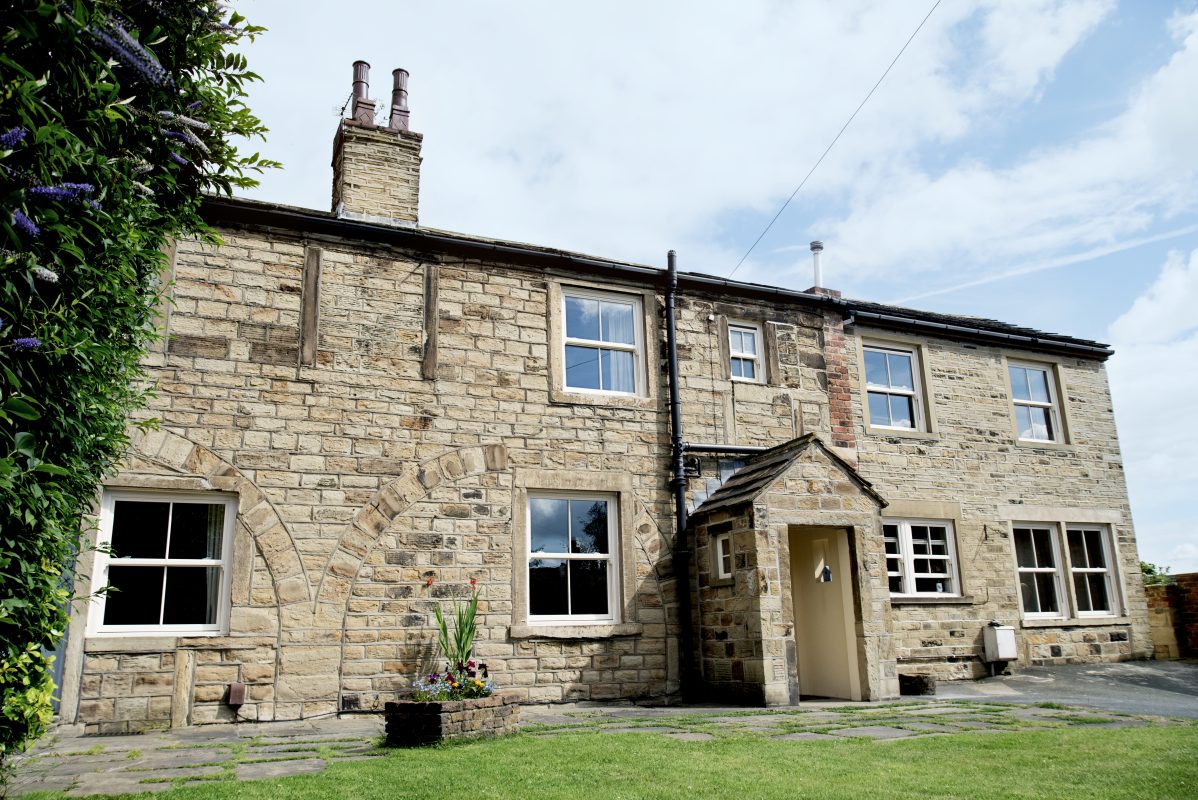 Victorian style white uPVC sliding sash windows on a heritage brick home