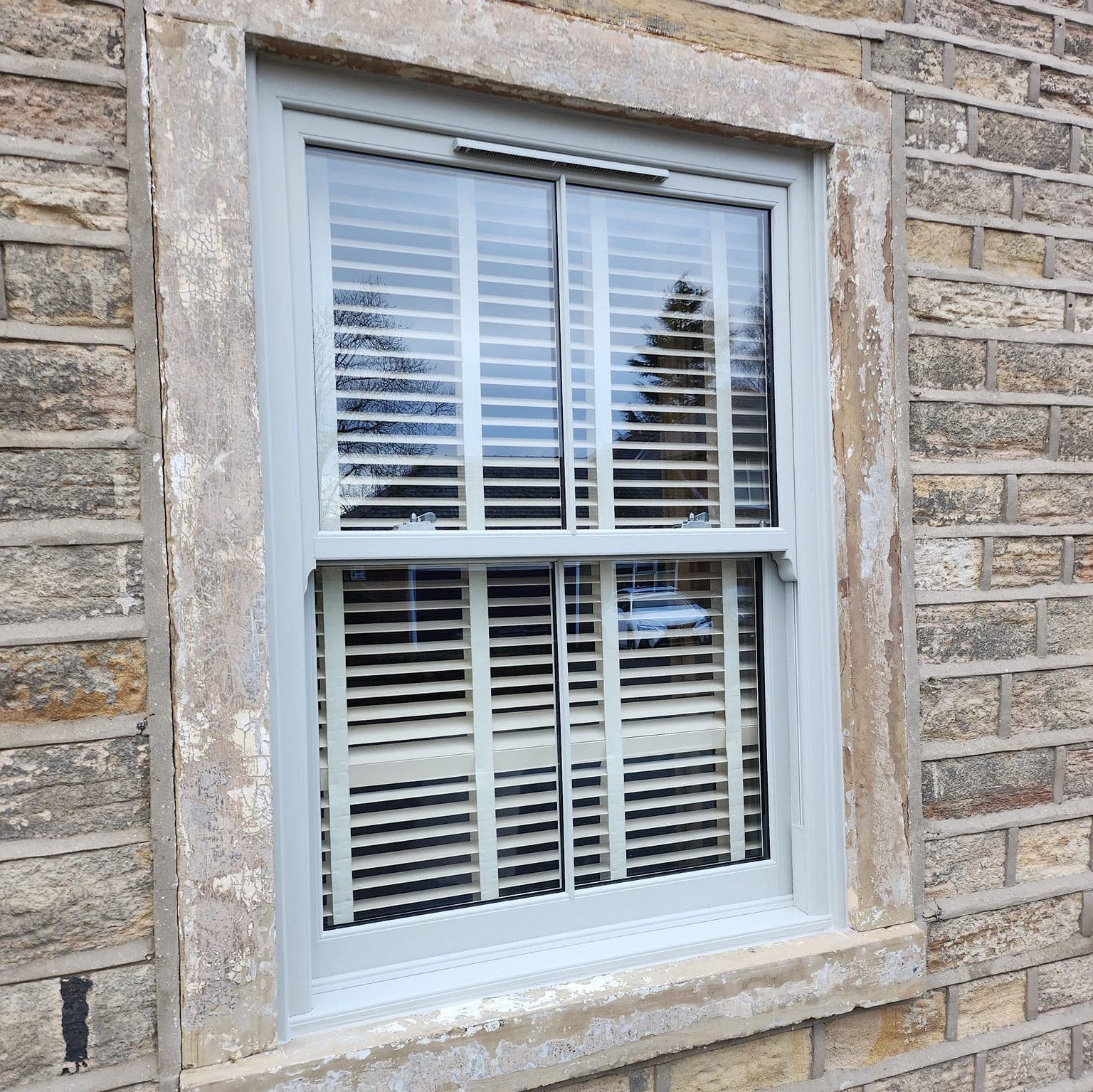light grey uPVC sash windows with blinds image from outside with authentic looking traditional design and slim midrail

