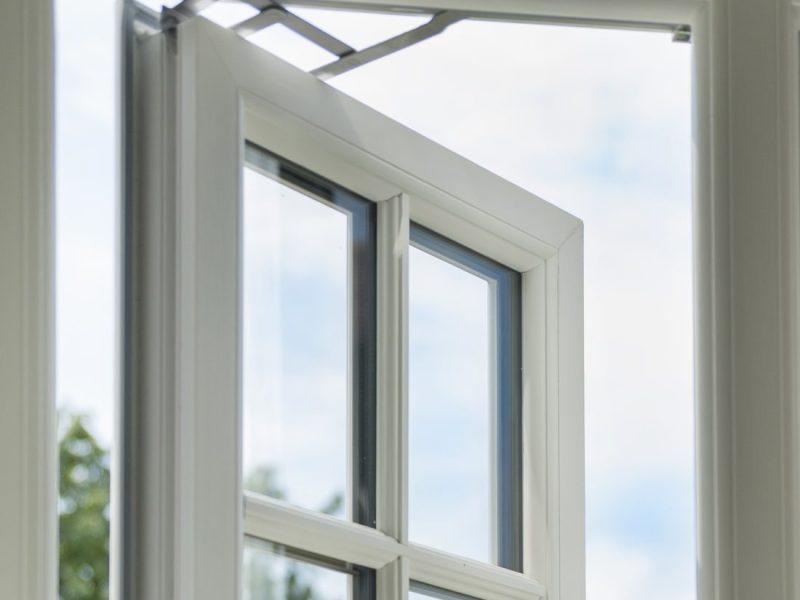 Close-up of a friction stay mechanism on a uPVC casement window, allowing smooth and adjustable opening