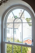 White arched uPVC sliding sash window with elegant frame and sash design