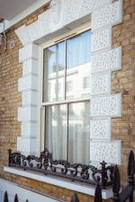 Cream uPVC sliding sash window fitted on exterior wall of a traditional home