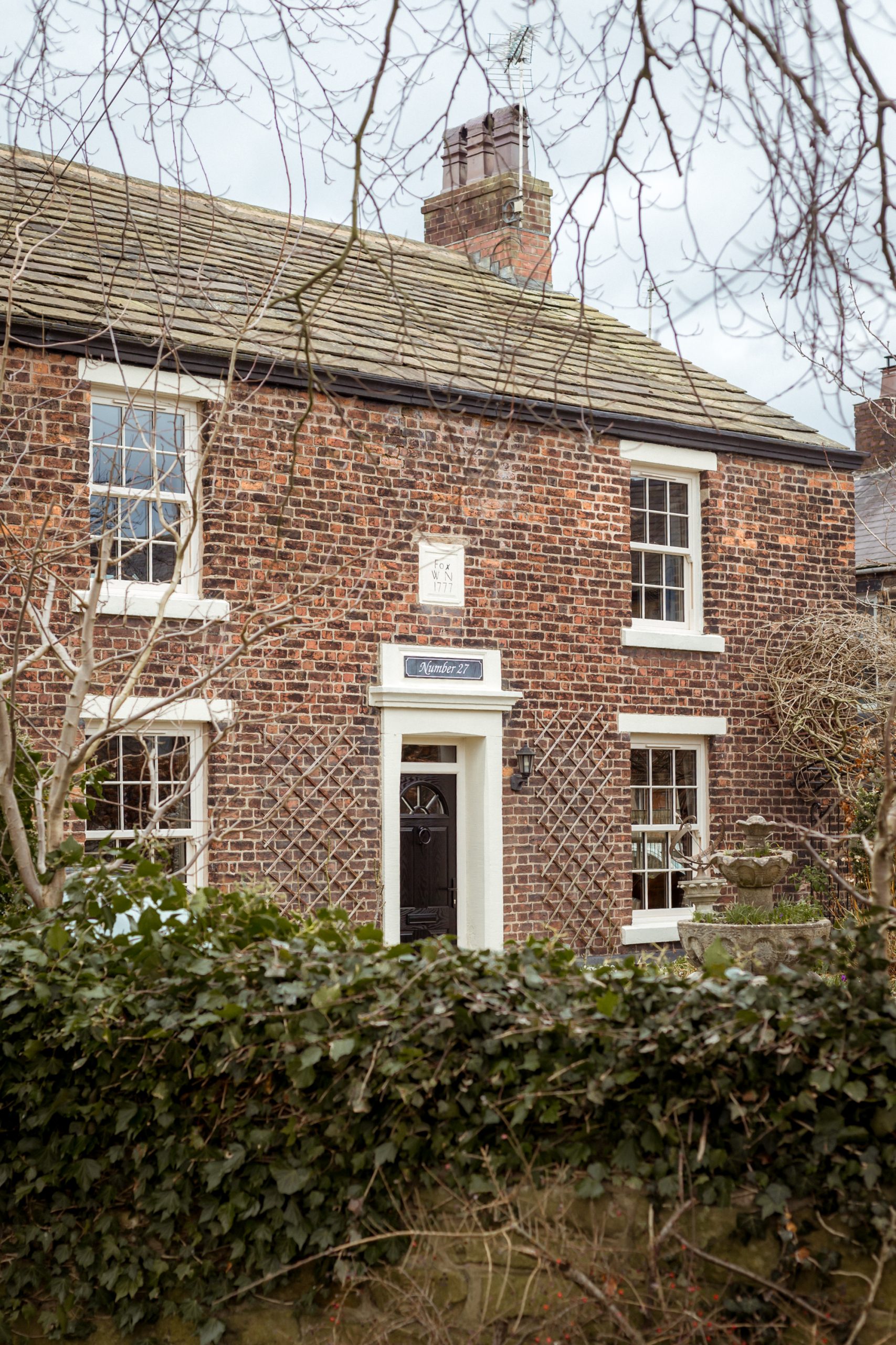 Cream uPVC casement door complementing sash windows on heritage home.