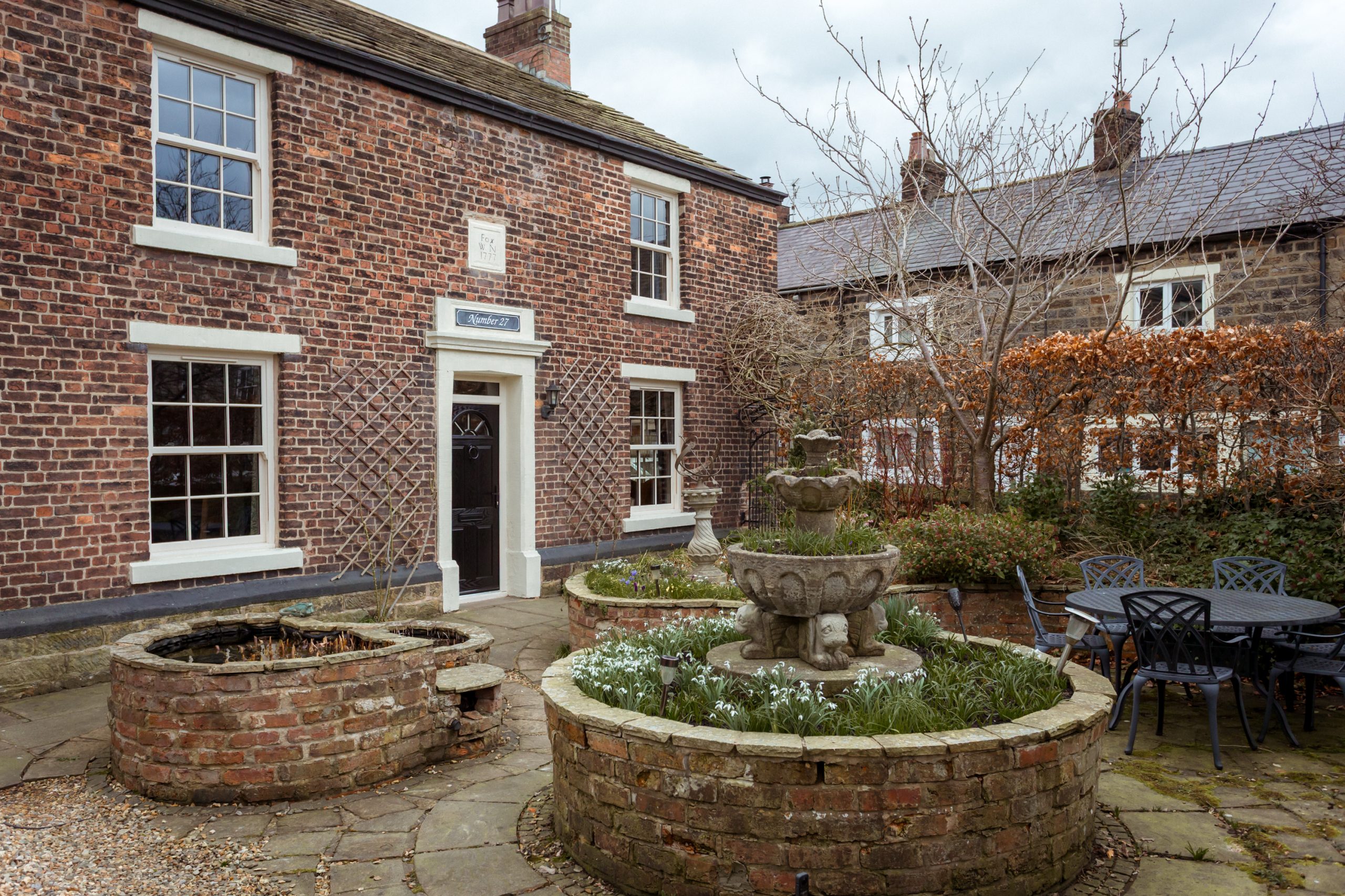 Heritage red-brick home updated with cream uPVC sash windows.