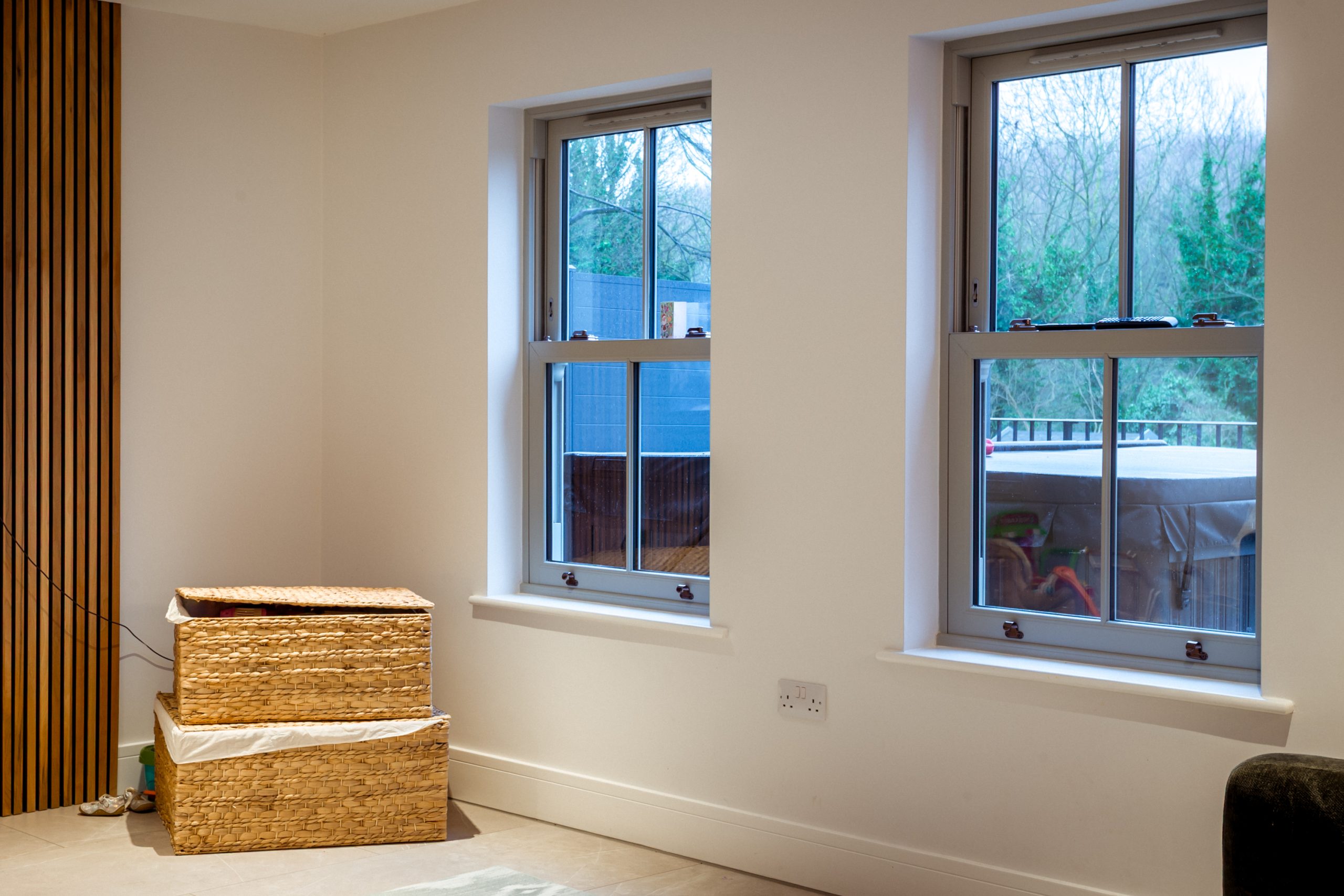Interior view of a bright living room with large Quickslide sash windows letting in natural light.