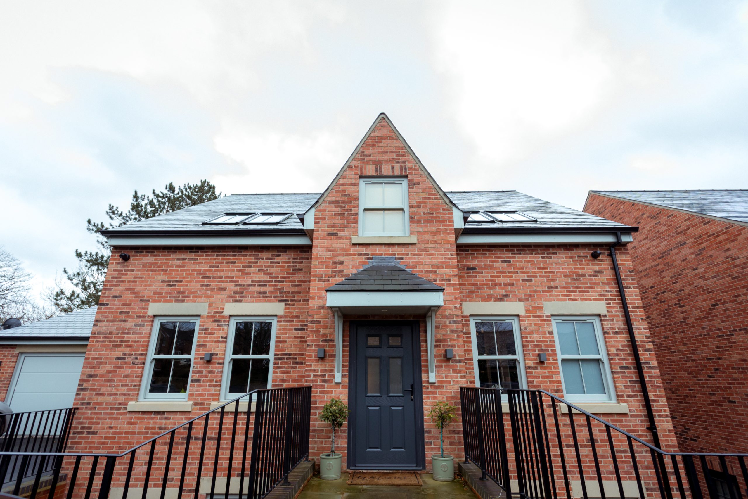 Front view of a new-build home featuring Agate Grey uPVC sliding sash windows by Quickslide
