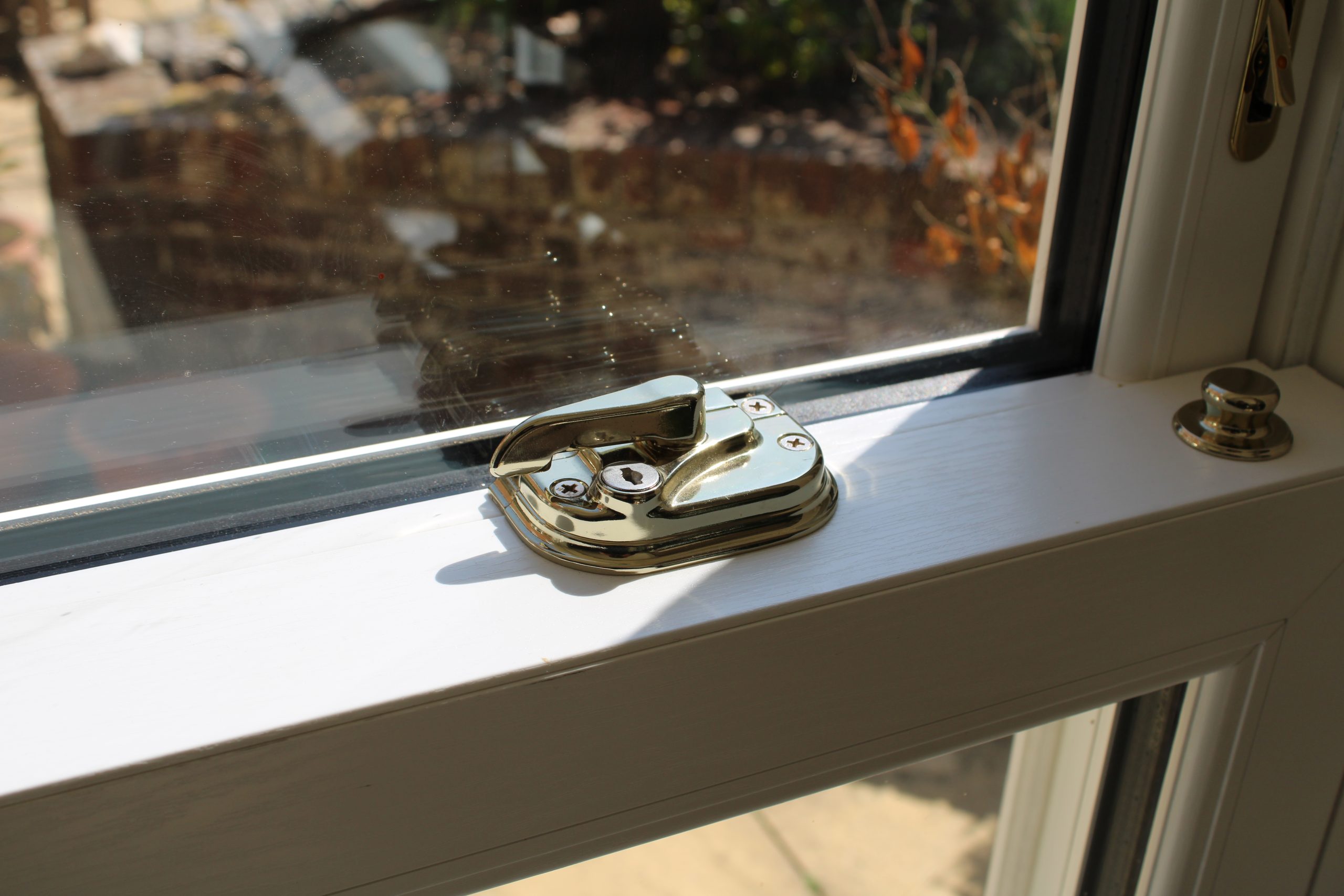 Close-up of white woodgrain sash window with traditional timber-look finish