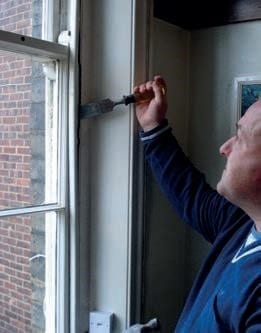 Sash window being chiselled for removal by installer