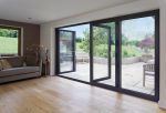 Black aluminium french doors open leading to a patio garden
