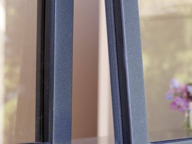 Close-up of a powder-coated aluminium casement window with a smooth, durable finish