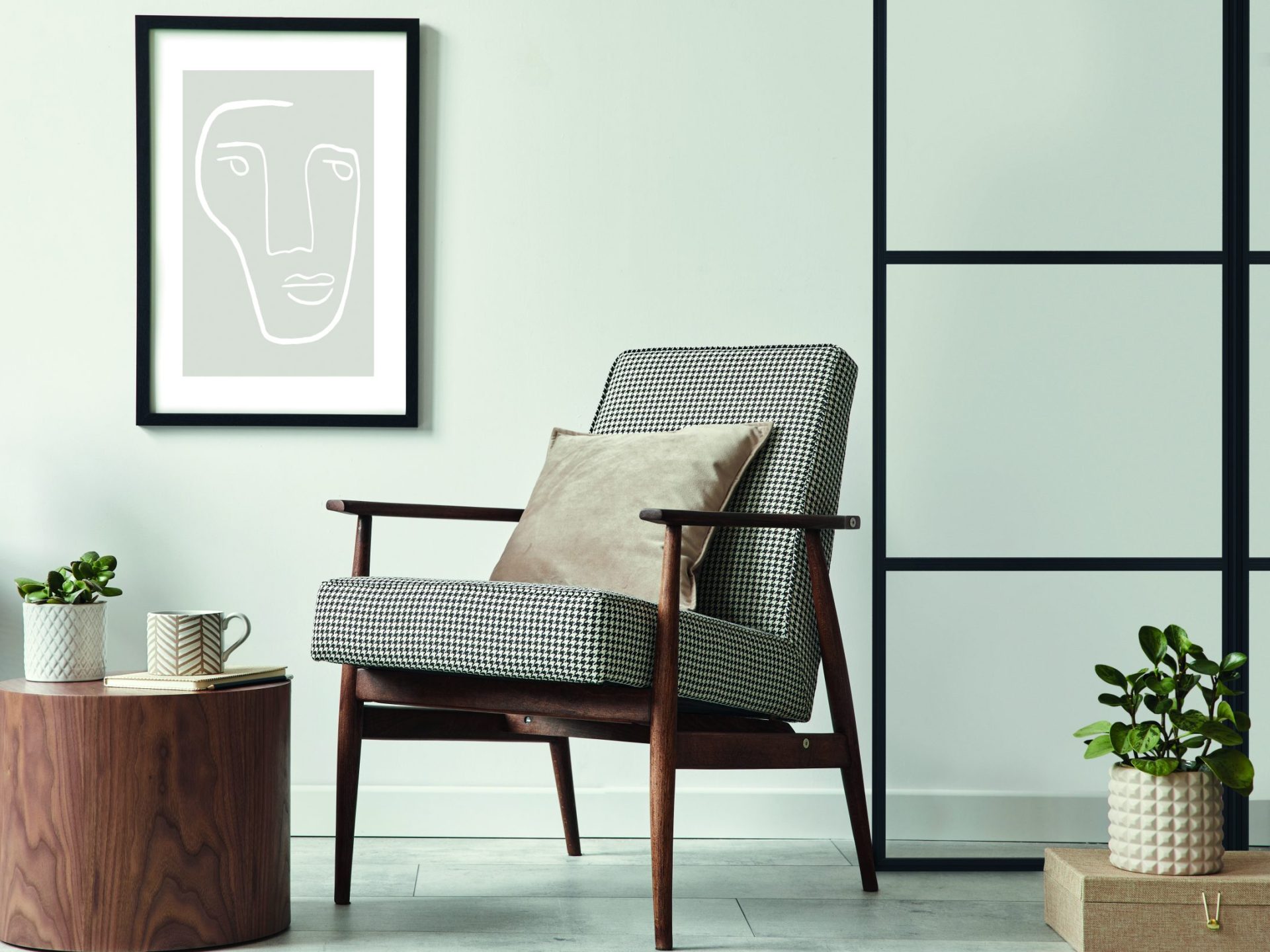 Scandinavian living room with design armchair, black poster, commode, and decor