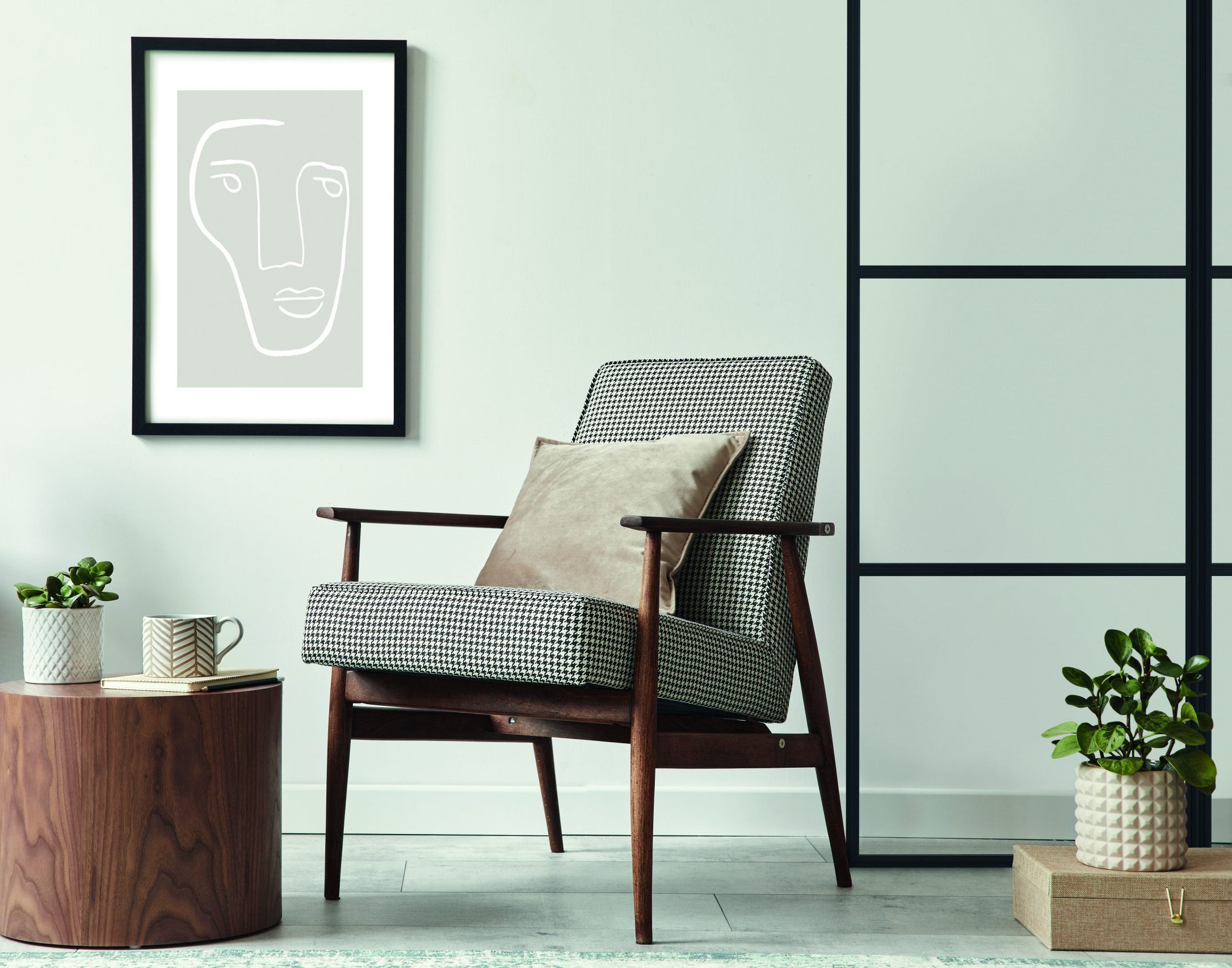 Scandinavian living room with design armchair, black poster, commode, and decor