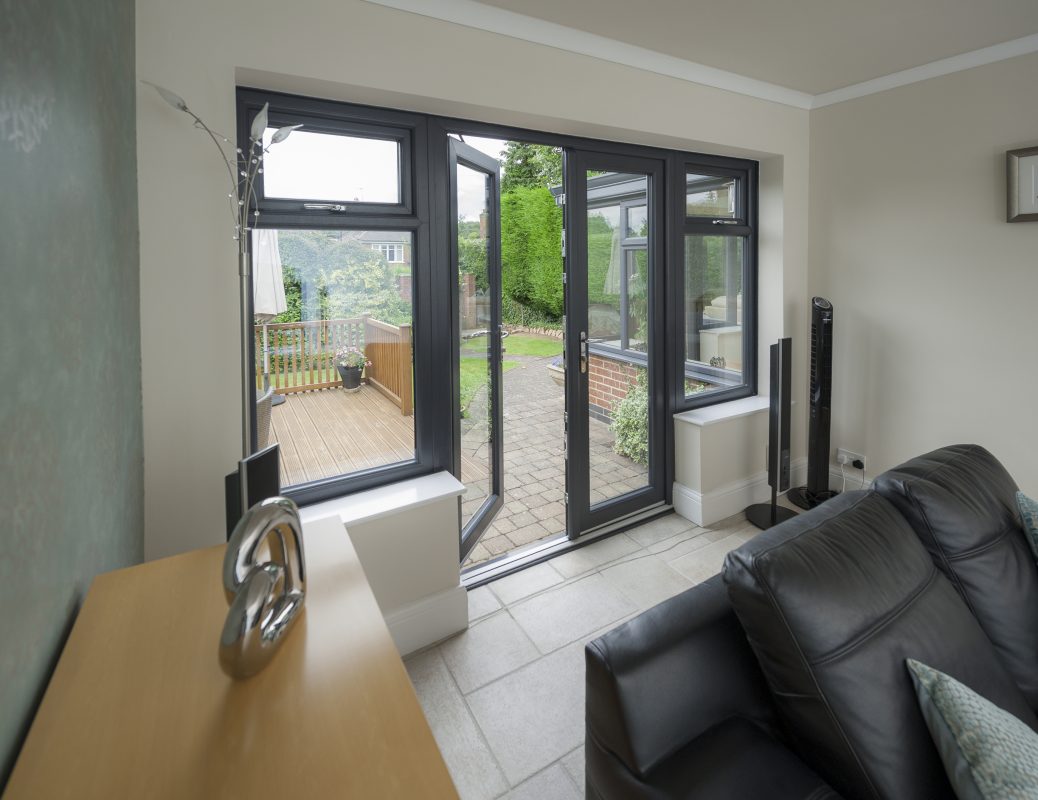 White uPVC French doors with large glass panels, opening onto a garden patio, providing a classic and stylish entrance.