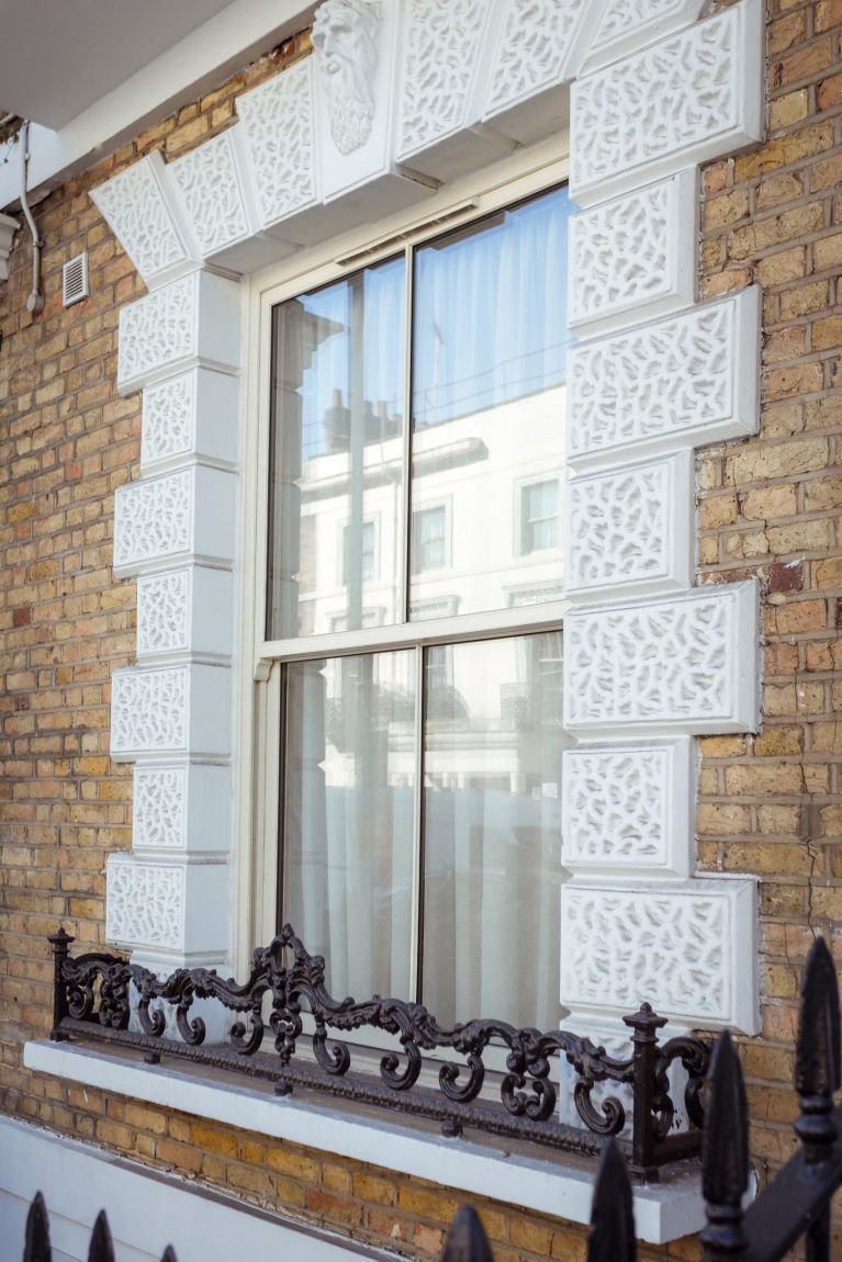 Cream uPVC sliding sash window fitted on exterior wall of a traditional home
