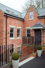 Red brick home featuring multiple agate grey uPVC sliding sash windows