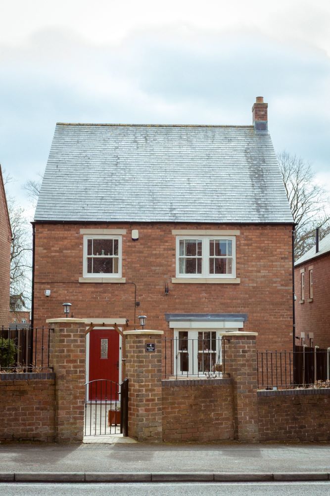 Red brick home with new cream uPVC sash windows adding a stylish, traditional finish