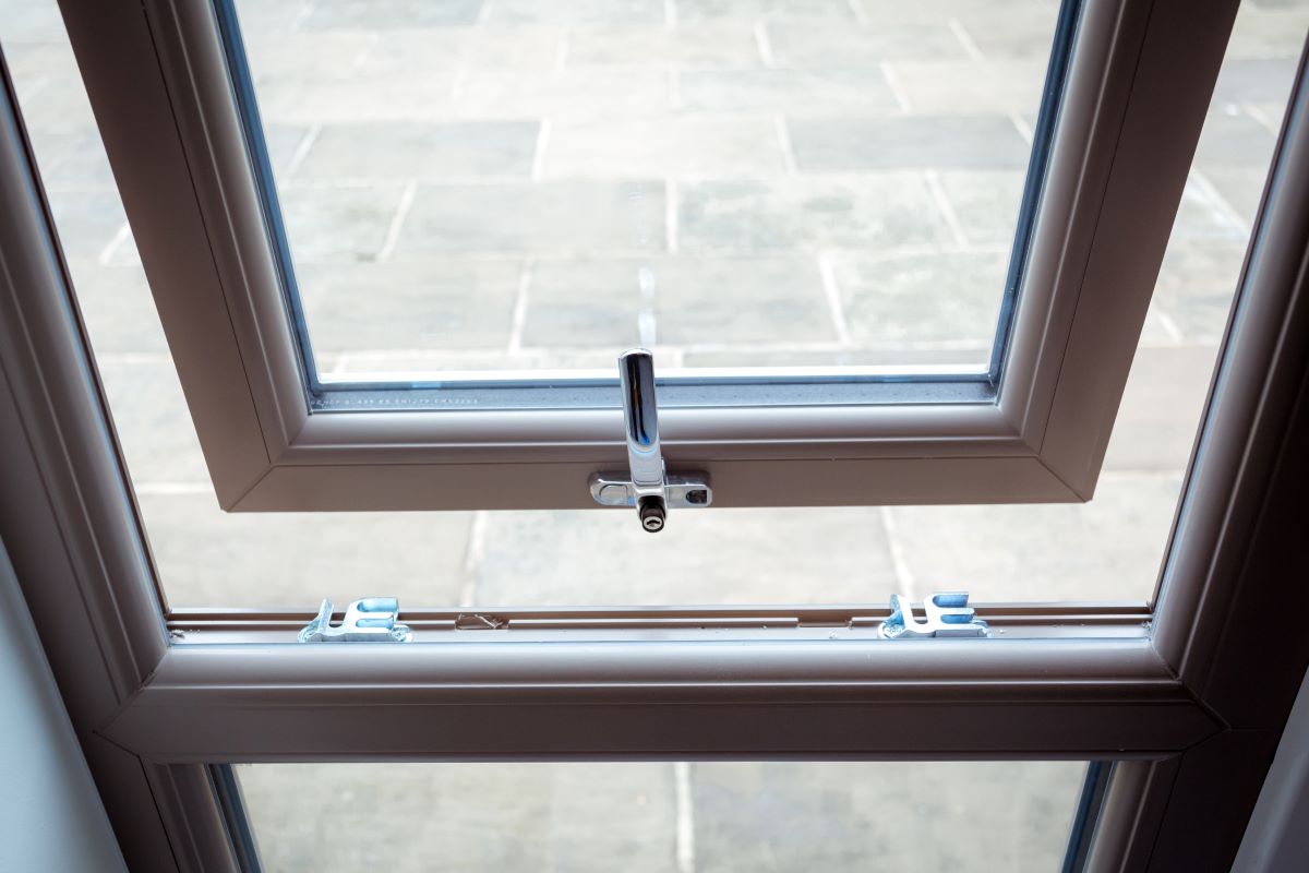 White uPVC casement window hinged at the top, opening outwards from the bottom.