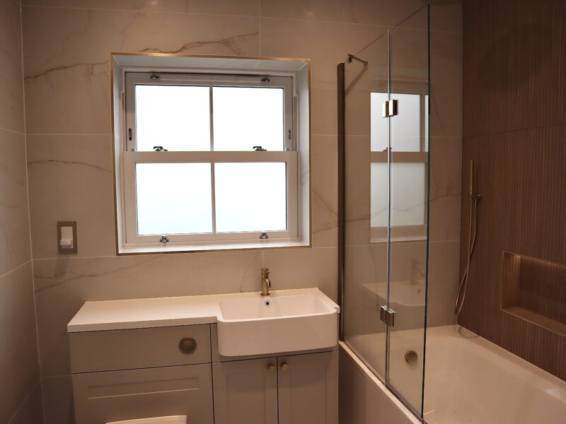 Interior view of a modern bathroom featuring an agate grey sash window providing natural light