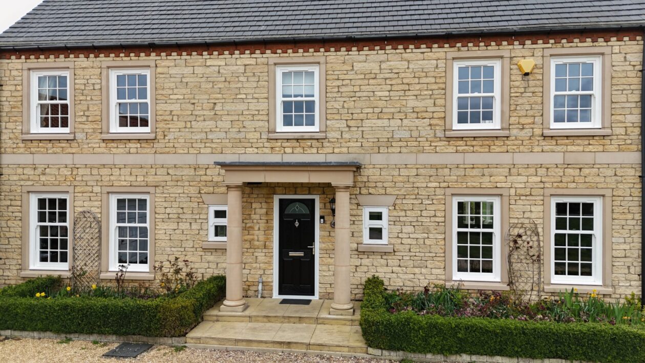 White woodgrain uPVC sliding sash windows replicating traditional timber design