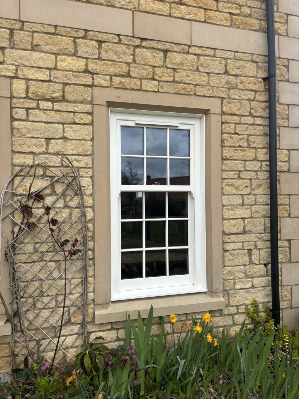 Exterior of Georgian-style home with replacement uPVC sliding sash windows in conservation area