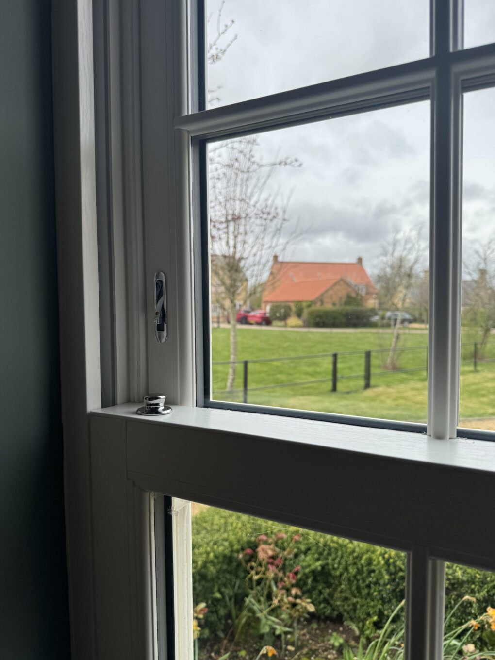 Internal view of Georgian-style uPVC sash window with white woodgrain finish and traditional bar layout