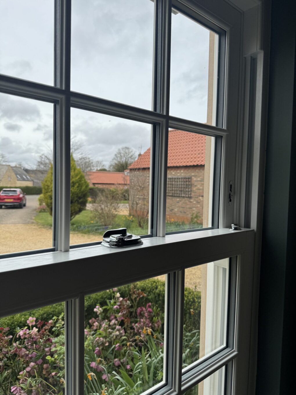 Close-up of uPVC sliding sash window showing woodgrain finish