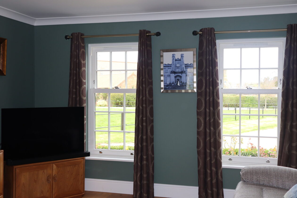 Interior room with uPVC sliding sash windows allowing natural light into a period-style home